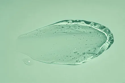Transparenter Gel-Klecks auf mintgrünem Hintergrund (Aloe Vera)